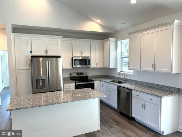 a kitchen with stainless steel appliances granite countertop a sink a stove a refrigerator and cabinets