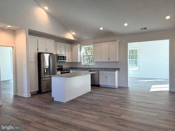 a kitchen with a refrigerator and a stove top oven