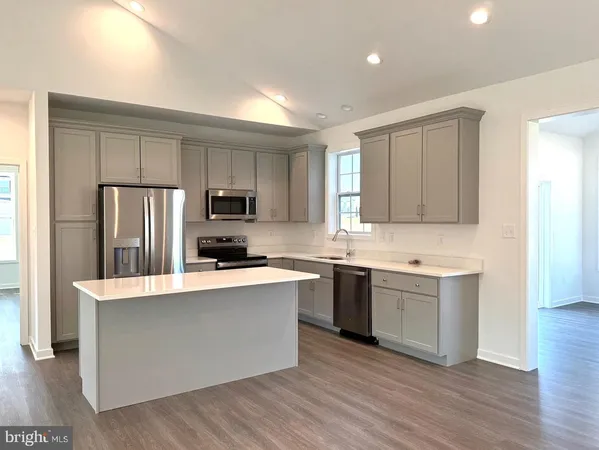a large kitchen with a center island stainless steel appliances and cabinets