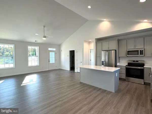 a kitchen with stainless steel appliances kitchen island granite countertop wooden floors and view living room