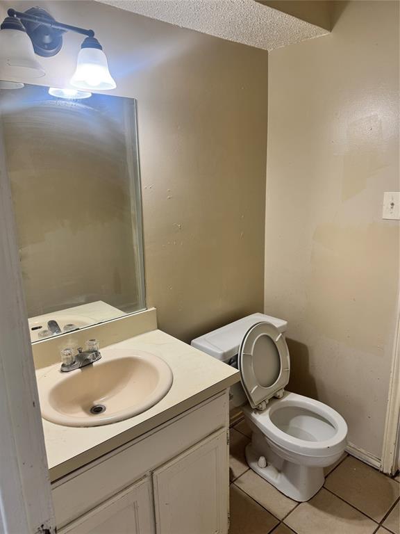 5617 Mansfield Road Arlington, TX 76017 - Photo 15 of 15 Bathroom featuring a single vanity with an integrated sink, built-in cabinetry, a wall-mounted mirror, and overhead vanity lighting