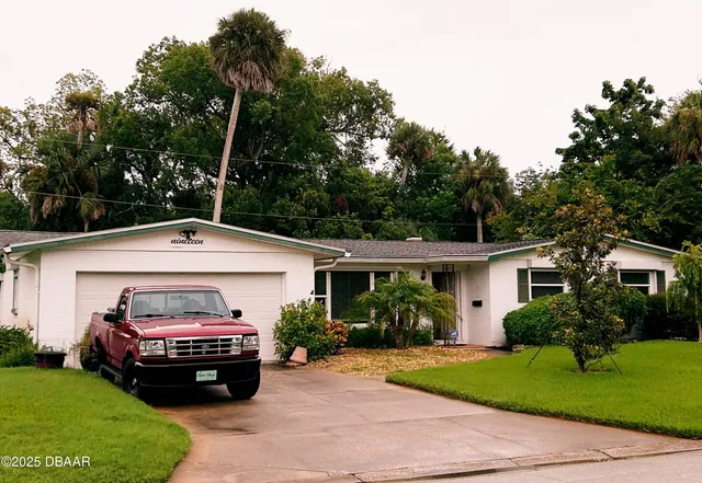 a car parked in front of a house and a garden