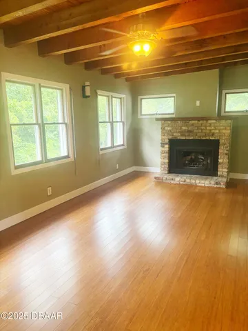 a view of empty room with wooden floor and fireplace