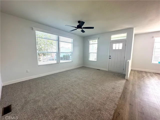 an empty room with fan and windows
