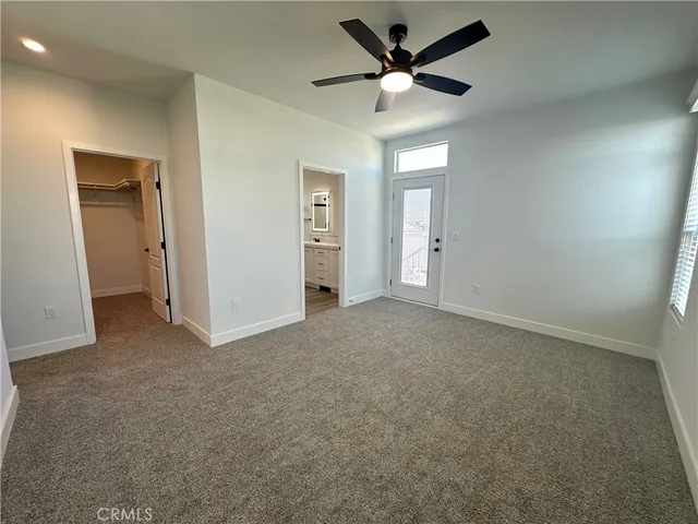 an empty room with a ceiling fan and a window