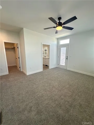 an empty room with windows and fan view