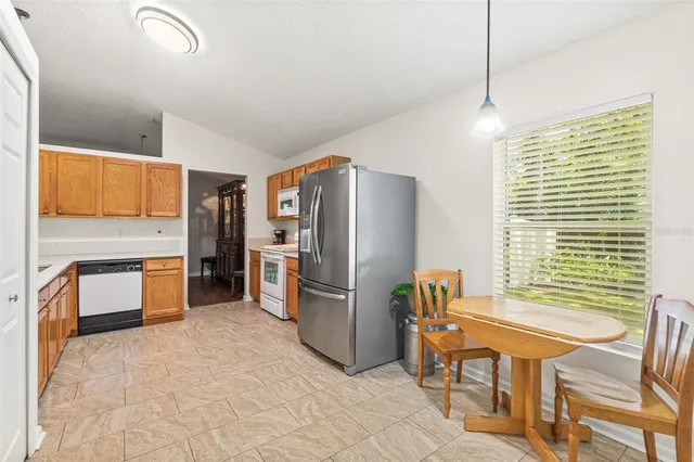 a large kitchen with stainless steel appliances granite countertop a refrigerator and a stove top oven