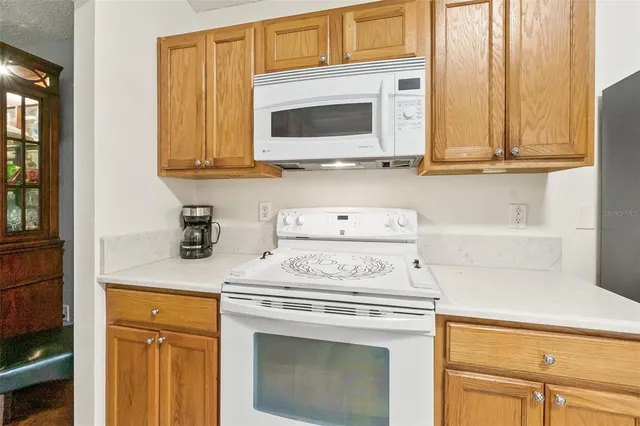 a kitchen with stainless steel appliances granite countertop a sink a stove and cabinets