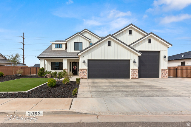 2092 South 3010 East St. George, UT 84790 - Photo 1 of 1 Modern inspired farmhouse featuring board and batten siding, an attached garage, driveway, covered porch, and brick siding