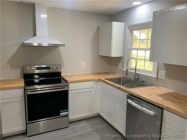 a kitchen with a stove sink and window