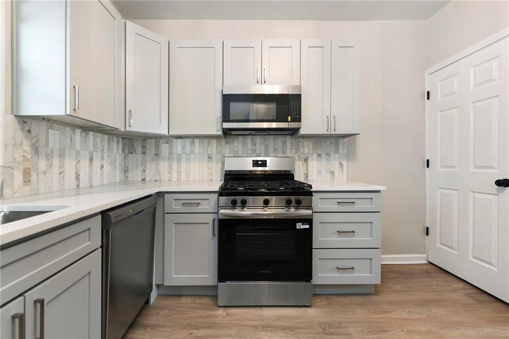 440 Ruxton Street Pittsburgh, PA 15211 - Photo 13 of 37 a kitchen with stainless steel appliances granite countertop a stove and a microwave