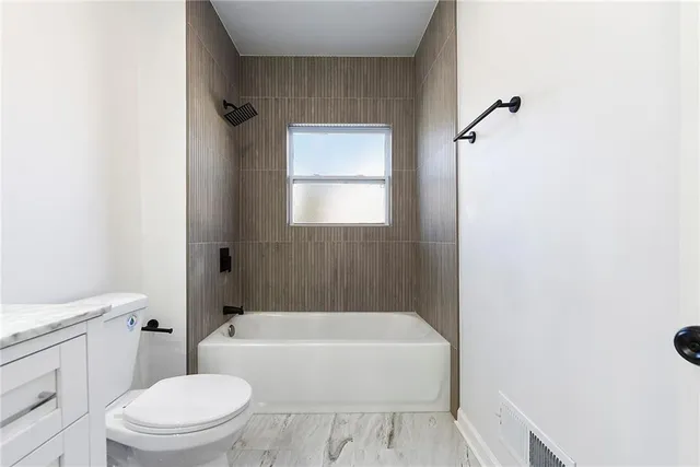 a bathroom with a toilet a sink and bathtub