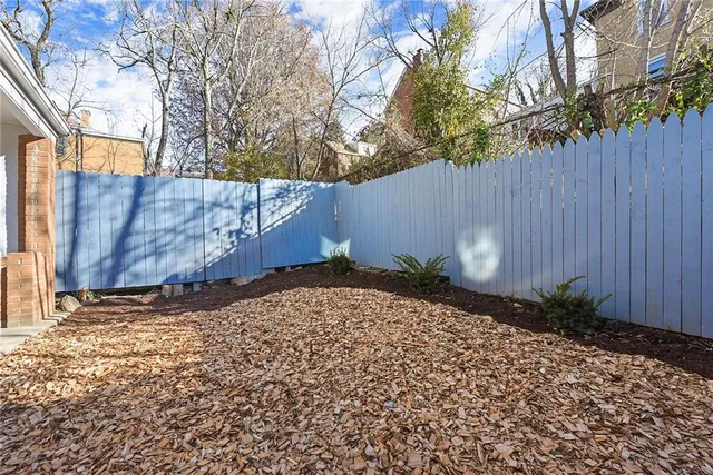 a view of a house with a yard and wooden fence
