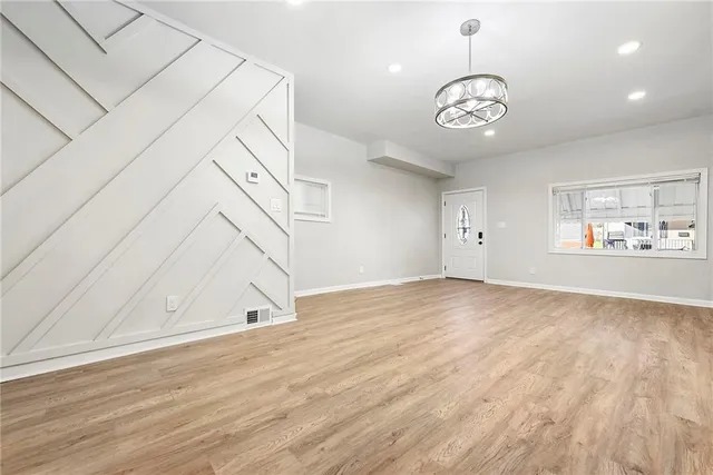 an empty room with wooden floor and stairs