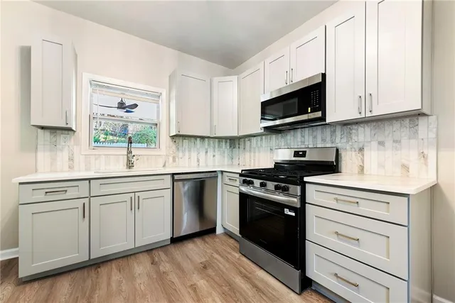 a kitchen with white cabinets and appliances