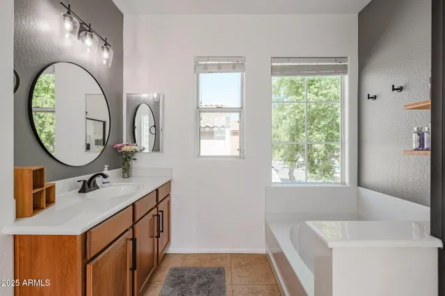 a en suite bathroom with a granite countertop sink and a mirror
