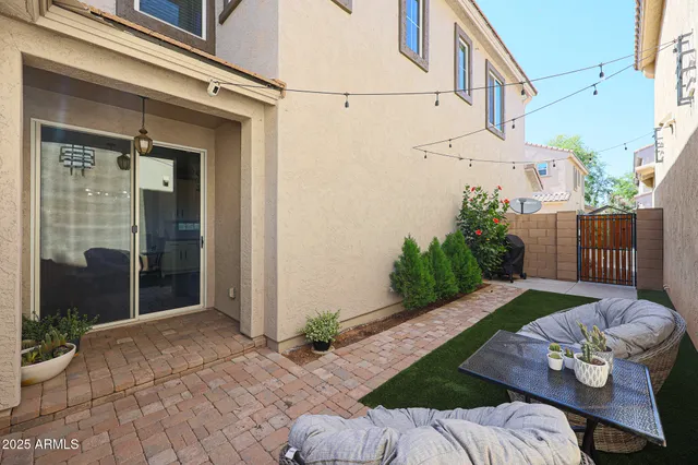 a backyard of a house with table and chairs