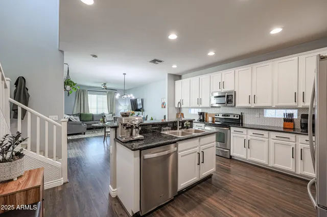 a kitchen with granite countertop a sink stove and cabinets