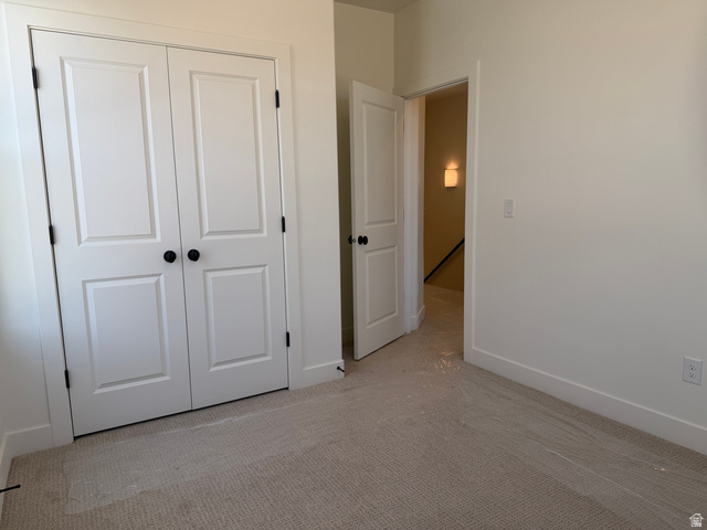 10995 South Freestone Road, Unit 109 South Jordan, UT 84009 - Photo 12 of 20 Unfurnished bedroom with light carpet and a closet