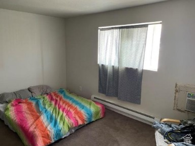 590 Pilot Avenue Wendover, UT 84083 - Photo 7 of 20 Carpeted bedroom featuring a baseboard heating unit and a wall mounted air conditioner