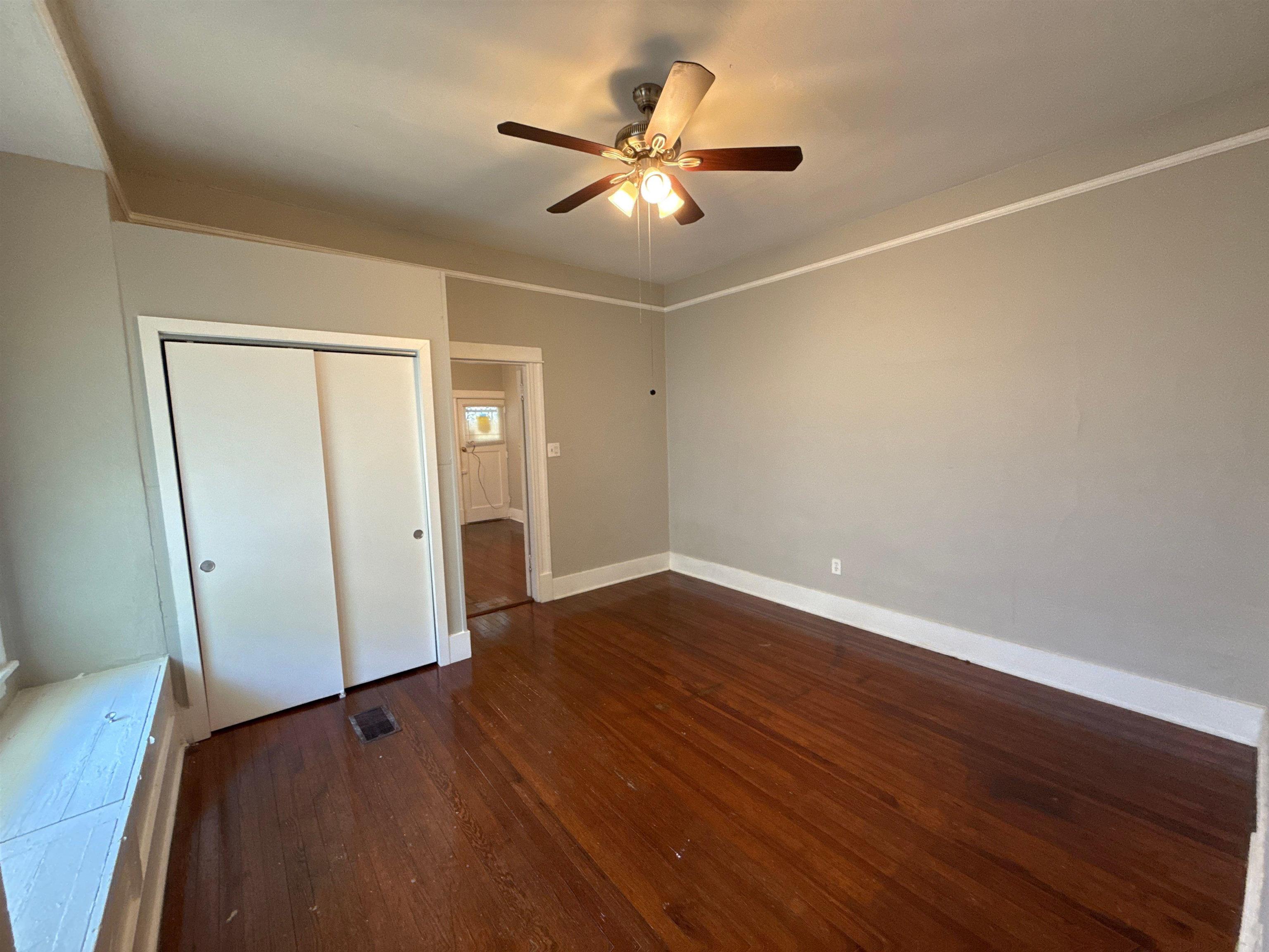1053 Fleece Place Memphis, TN 38104 - Photo 2 of 14 an empty room with wooden floor and a ceiling fan