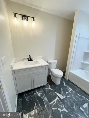 a bathroom with a sink toilet and a mirror