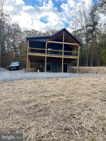 a view of a house with a yard and seating space
