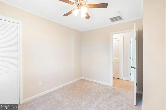 an empty room with a ceiling fan and a window