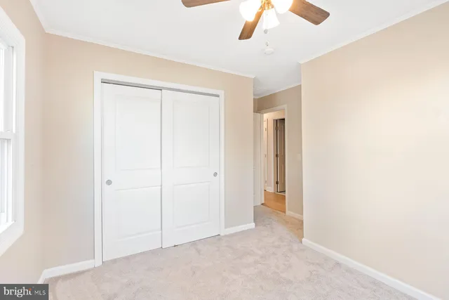 an empty room with chandelier fan