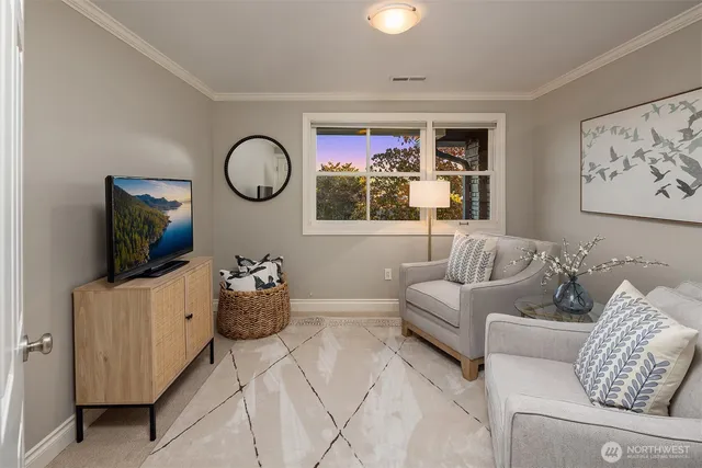 a living room with furniture a flat screen tv and a window