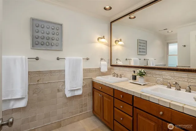 a bathroom with a double vanity sink a mirror and a shower