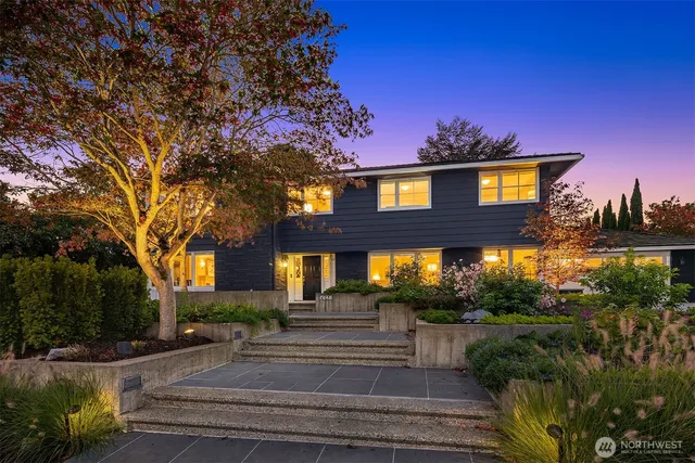 a front view of a house with a yard and potted plants