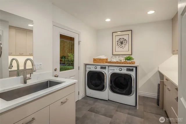 a utility room with sink dryer and washer