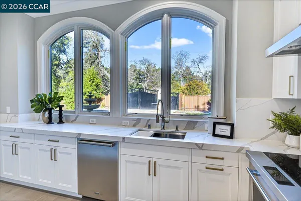 a kitchen with a sink a window and cabinets