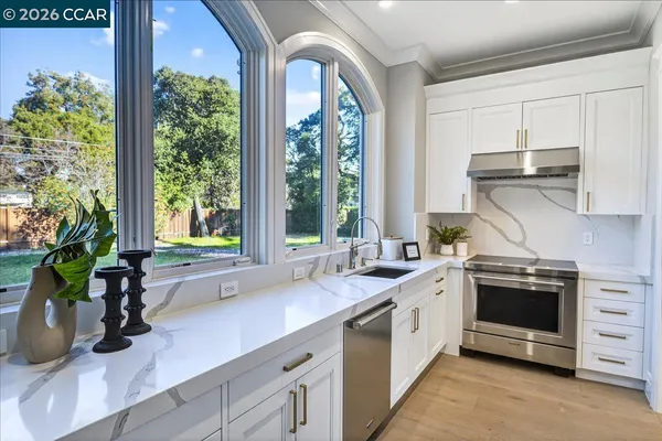 a kitchen with a sink a stove and cabinets