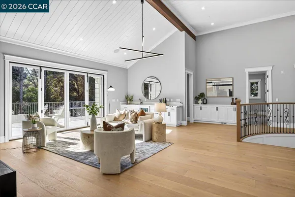 a living room with couches a coffee table and kitchen view with wooden floor