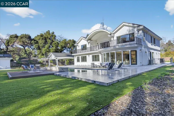 a front view of house with a garden and swimming pool