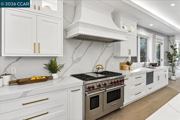 a kitchen with stainless steel appliances white cabinets and white stove