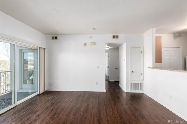 a view of a big room with wooden floor and windows
