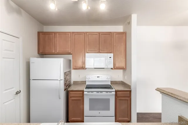 a kitchen with a refrigerator sink and cabinets