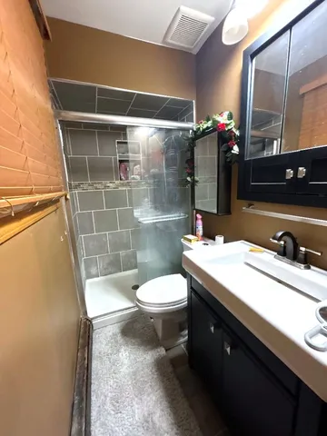 a bathroom with a sink a toilet a mirror and shower
