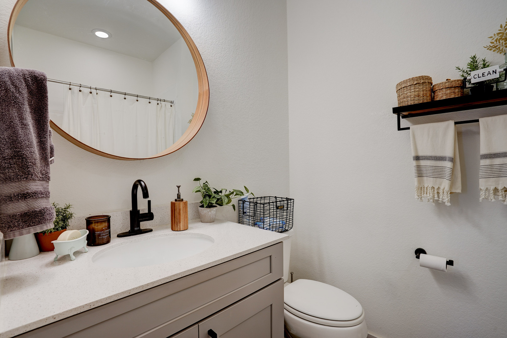 2240 Ringstaff Road Leander, TX 78641 - Photo 18 of 25 Bathroom featuring a gray vanity with an integrated sink, black faucet, and a round wood-framed mirror