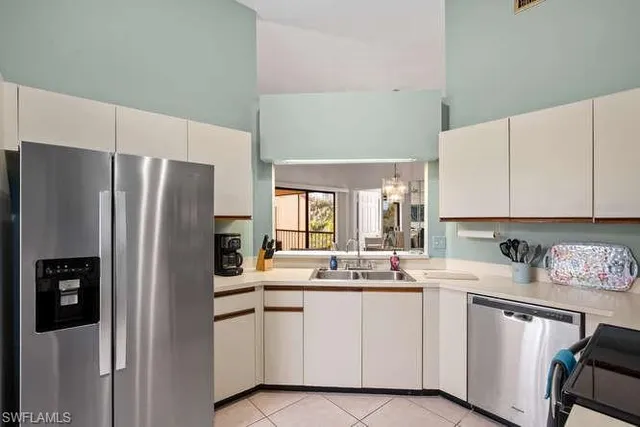 a kitchen with white cabinets and refrigerator