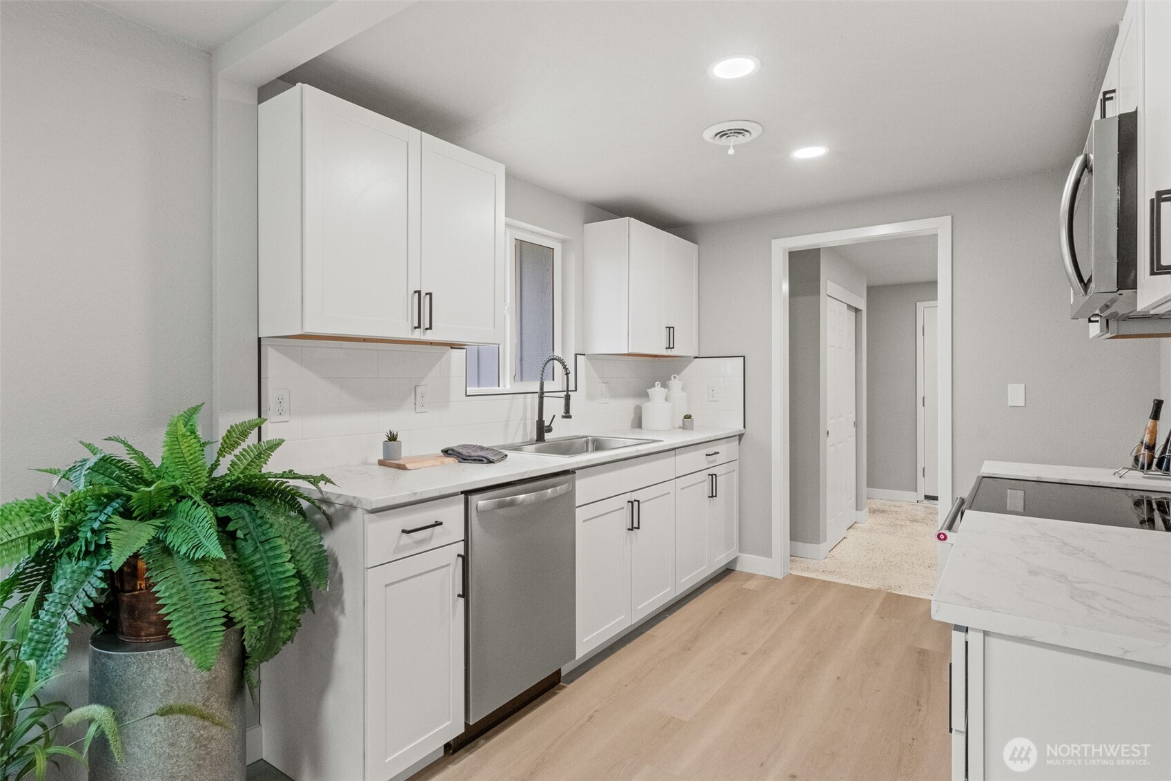 307 3rd Avenue Northeast Quincy, WA 98848 - Photo 6 of 26 a kitchen with white cabinets and a sink