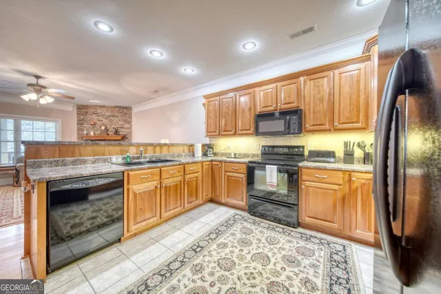 a kitchen with stainless steel appliances granite countertop a refrigerator stove top oven and sink