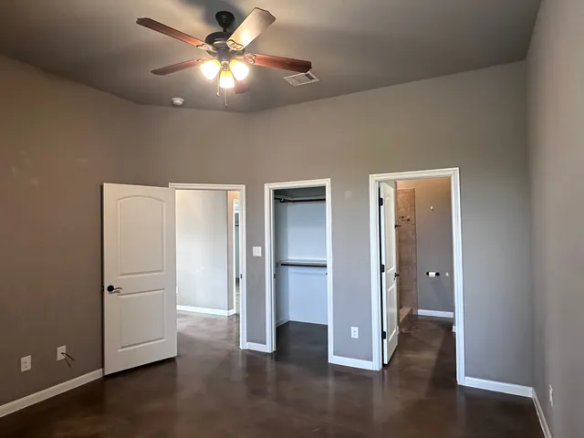 a view of an empty room with a window and a refrigerator