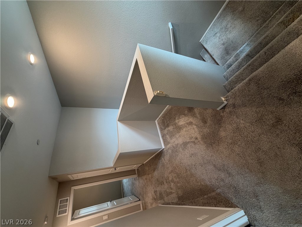 916 Riggs Flats Avenue North Las Vegas, NV 89086 - Photo 19 of 43 High ceilings and soft carpet define this multi-level landing and transition space.