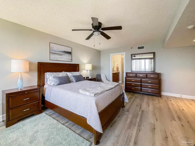 a bedroom with a large bed and ceiling fan