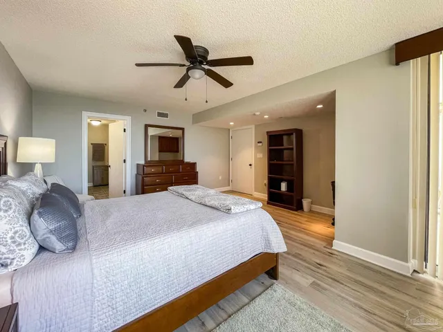 a spacious bedroom with a bed and a chandelier