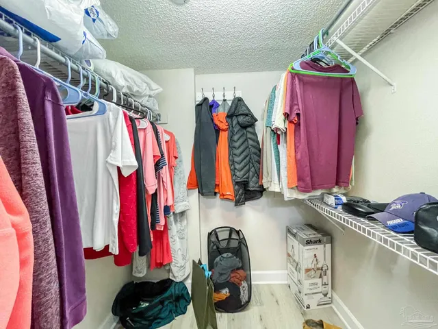 a view of a hallway to a livingroom and a livingroom with furniture wooden floor